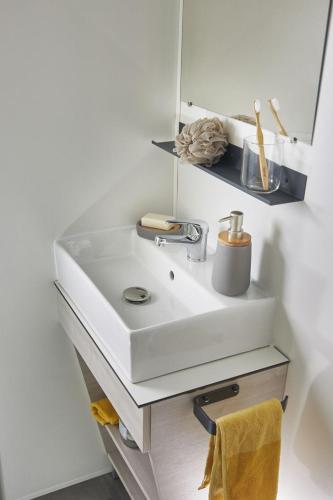 une salle de bain avec un lavabo blanc et un miroir dans l'établissement West Camping, à Perros-Guirec