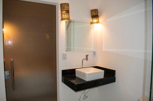 uma casa de banho com um lavatório e um espelho em Pousada Canto de Paz em Porto Seguro