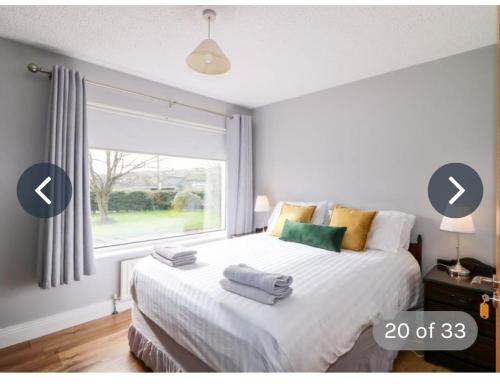 1 dormitorio con 1 cama grande y ventana en Rossgier bungalow en Lifford