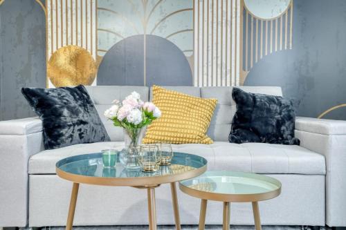 ein Wohnzimmer mit einem Sofa und einem Tisch mit Blumen darauf in der Unterkunft L'Elégant Chic-T2-Paris-Disneyland in Noisy-le-Grand