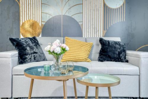 a living room with a couch and a table with flowers on it at L'Elégant Chic-T2-Paris-Disneyland JO Paris 2024 in Noisy-le-Grand