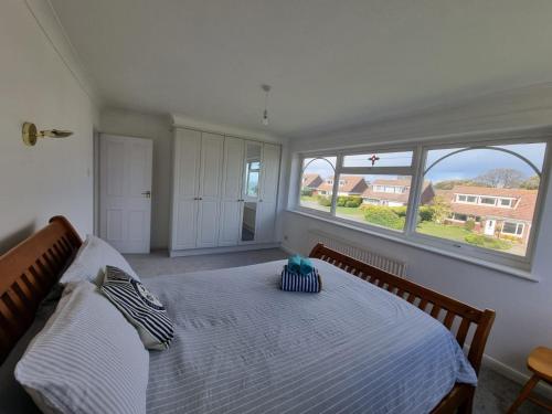 a bedroom with a large bed with two windows at Seasalt and Seasalt Cabin, Seaview in Seaview