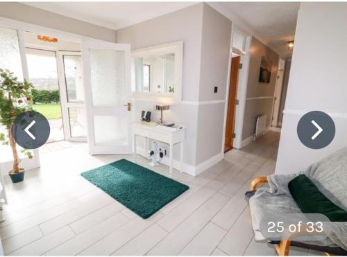 a living room with a couch and a green rug at Rossgier bungalow in Lifford