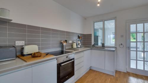 a kitchen with white cabinets and a counter top at Shambles in Llanmadoc