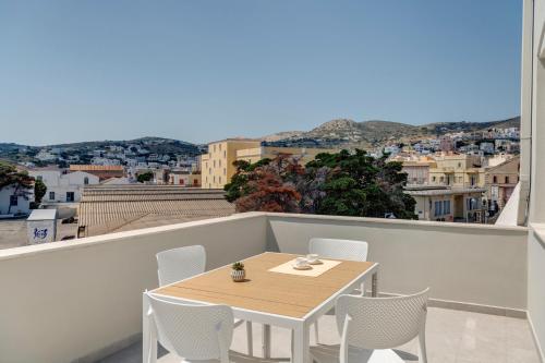 a table and chairs on a balcony with a view at Marion Suite in Ermoupoli