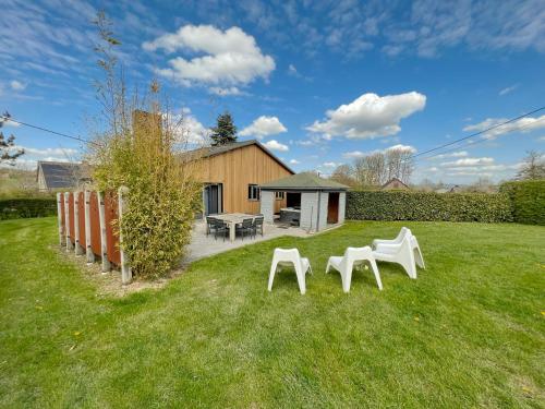 two white chairs and a table in a yard at Gite Ard'zen in Noiseux