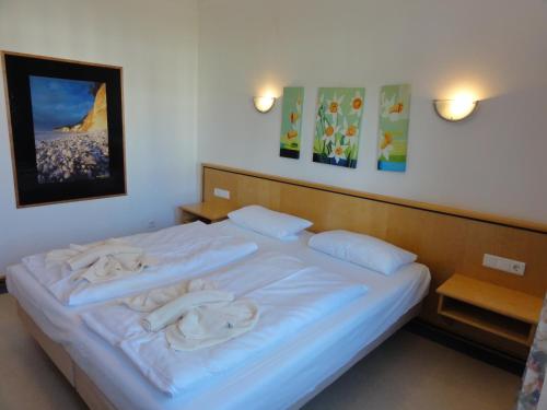 ein Schlafzimmer mit einem weißen Bett und Handtüchern darauf in der Unterkunft Ferienwohnung im Dünenpark in Binz