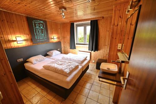 um quarto com uma cama num quarto de madeira em Gite Ard'zen em Noiseux