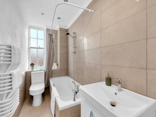 ein weißes Bad mit einem WC und einem Waschbecken in der Unterkunft Pass The Keys - Spacious Modern 2BR Flat for 6, 3min walk to Hammersmith Station in London