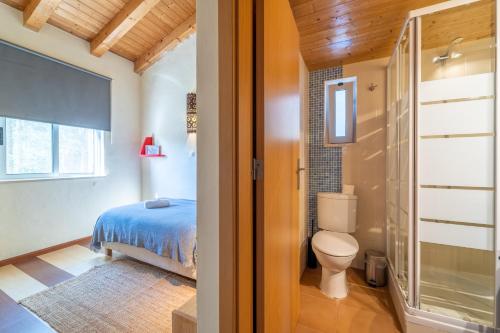 ein Bad mit einem Bett und einem WC in einem Zimmer in der Unterkunft Aljezur Villas in Aljezur