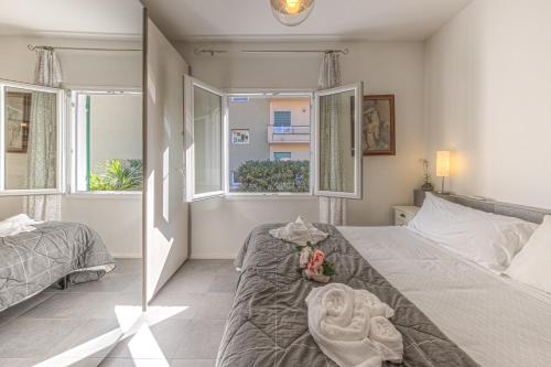 ein Schlafzimmer mit zwei Betten und zwei Fenstern in der Unterkunft VILLA TORETTI Centro, Relax e Parcheggio Privato in Rapallo