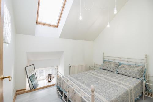 尤尔马拉Beachfront Art Gallery Mansard One Bedroom Suite in Historic Bath-House的白色房间里有一张床的卧室