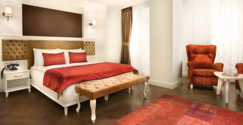 a hotel room with a bed, chair, table and lamps at Astan Hotel Galata in Istanbul