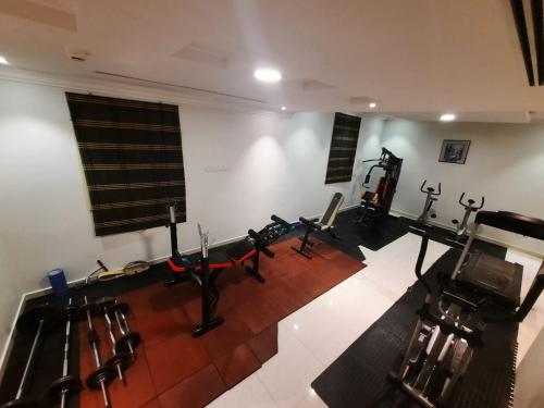 a gym with rows of exercise equipment in a room at Al Masem Serviced Apartments - Gharnata - Exit 9 in Riyadh