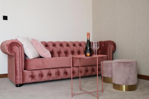 a red couch with a bottle of wine on a table at M&W Hotel Wronowski in Łomża