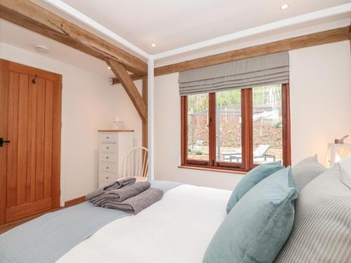 a bedroom with a white bed and a window at Beech Barn The Rookery in Kingsbridge
