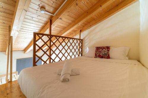 Cama grande en habitación con techo de madera en Aljezur Villas, en Aljezur