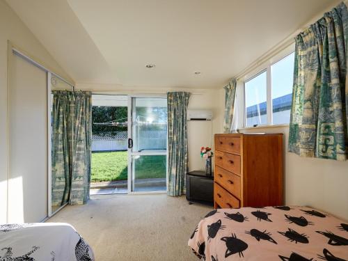 カイコウラにあるTorquay Central - Kaikoura Holiday Homeのベッドと大きな窓のある寝室