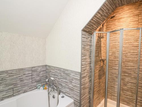 a bathroom with a shower and a bath tub at The Cheese Loft in Carmarthen