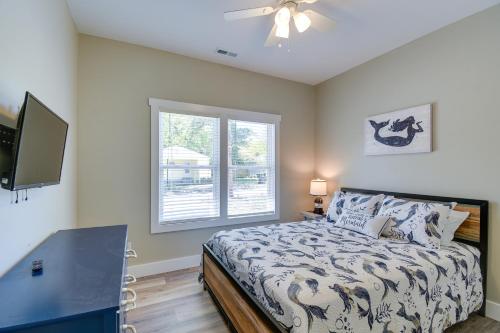 a bedroom with a bed with a ceiling fan and a window at Charming Ocean Isle Beach Home about 1 Mi to Beach! in Ocean Isle Beach