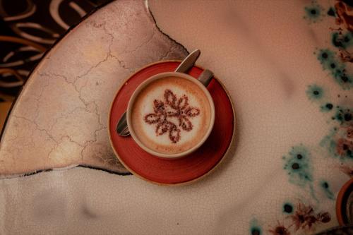 a cup of coffee on a plate on a table at The Heritage Boutique Accommodation in Rabat