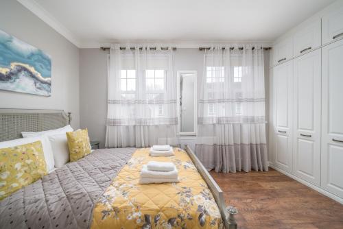 a bedroom with a bed with a yellow blanket at Delightful 3 Bed House by Canary Wharf in London