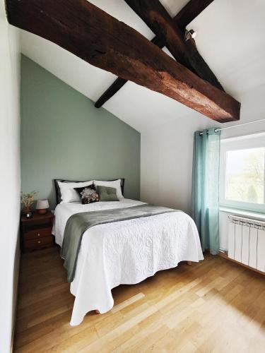 Un dormitorio con una cama blanca y una ventana. en Chambres d'hôtes - Les Varennes, en Saint-Georges-de-Reneins