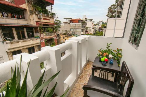 a balcony with a table and chairs on a building at La Renta Hotel & Spa in Hanoi
