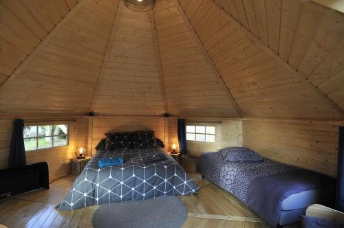 ein Schlafzimmer mit einem Bett und einem Sofa in einem Zimmer in der Unterkunft KOTA Finlandais ETRETAT in Les Loges