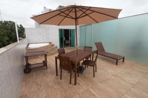 a wooden table and chairs with an umbrella on a patio at Hotel Vale Do Xingu in Altamira