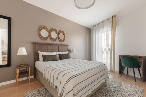 a bedroom with a bed and two mirrors on the wall at OVELIA Poissy - Les Romantiques in Poissy