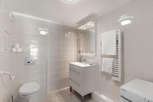 biała łazienka z toaletą i umywalką w obiekcie OVELIA Poissy - Les Romantiques w mieście Poissy