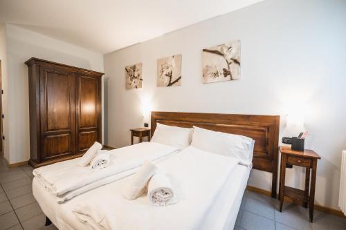 a bedroom with a bed with two towels on it at La Cantinota - Locanda De Manincor Rooms in Arco