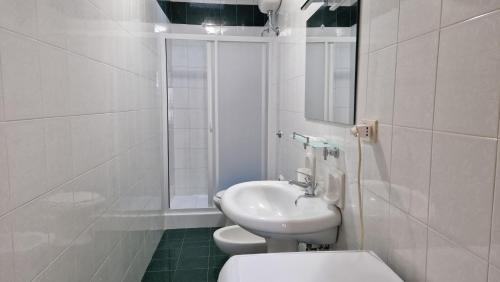 bagno bianco con lavandino e servizi igienici di Appartamenti in Centro a Vieste a Vieste