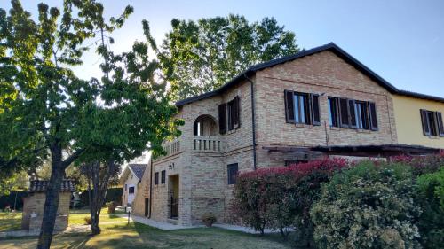 una vecchia casa di mattoni con un albero di fronte di Agriturismo Terralieta a Roseto degli Abruzzi