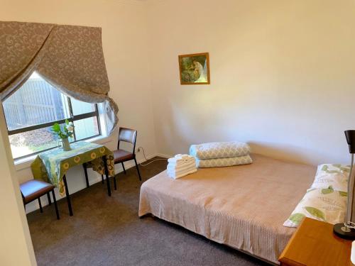 a bedroom with a bed and a desk and a window at Comfy Private rooms in Braybrook in Braybrook