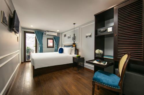 a bedroom with a bed and a table and a chair at La Renta Hotel & Spa in Hanoi
