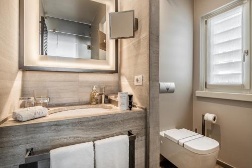 a bathroom with a tub and a toilet and a sink at Villa Grey in Forte dei Marmi