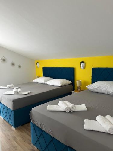 two beds sitting next to each other in a room at Guesthouse Villa Jurišić in Novalja