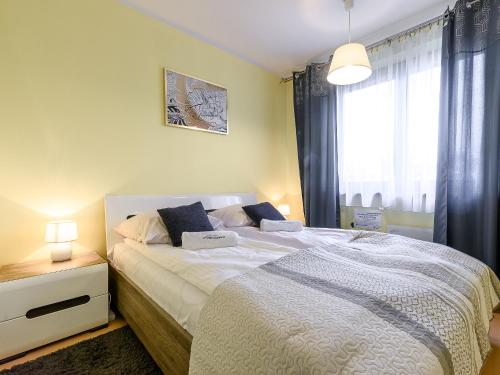 a bedroom with a large bed and a window at VisitZakopane - Stone Apartment in Zakopane