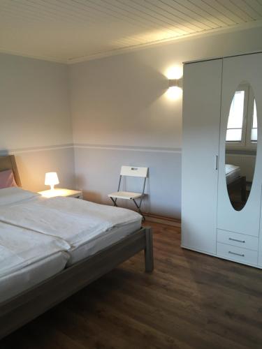 a bedroom with a white bed and a mirror at Ferienhaus am Neuklostersee in Neukloster