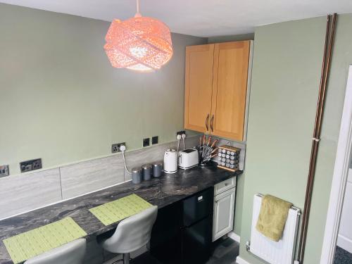 a kitchen with a sink and a counter with chairs at CozyComfy Apartment Leicester in Leicester