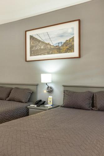 a hotel room with a bed and a picture on the wall at Hotel Nuve Gomez Palacio in Gómez Palacio