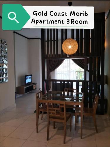 a dining room with a wooden table and chairs at Gold Coast Morib Rerost By Sweetime in Kampong Tanjong Pechah