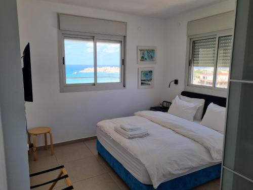 een slaapkamer met een bed en uitzicht op de oceaan bij Beachfront Gallery in Akko