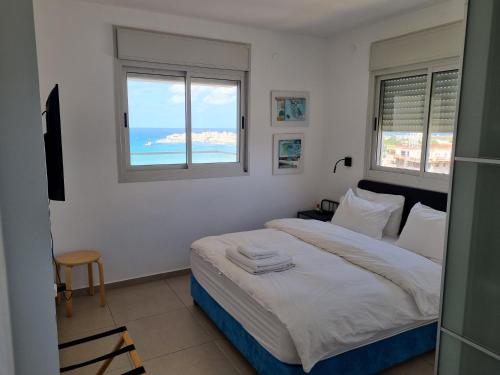 1 dormitorio con 1 cama y vistas al océano en Beachfront Gallery, en Acre