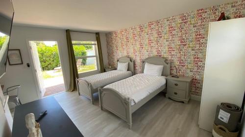 een slaapkamer met 2 bedden en een bakstenen muur bij 2 Min Walk To The Beach-all Renovated Studio #4 in Fort Lauderdale