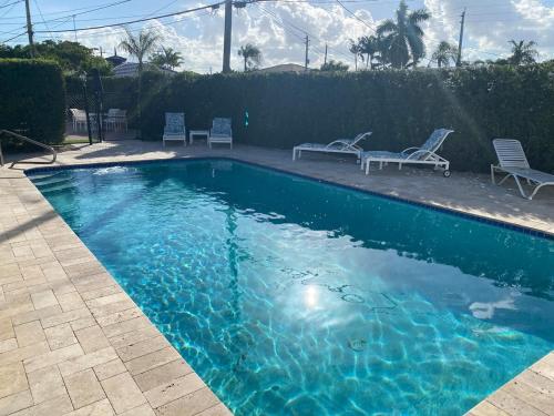 una piscina con due sedie a sdraio di 2 Min Walk To The Beach-all Renovated Studio #4 a Fort Lauderdale