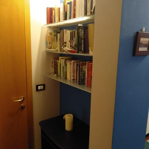 a book shelf filled with books next to a door at Mini appartamento con giardino in Fontanafredda