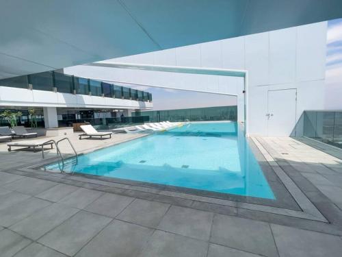 - un grand bâtiment avec une piscine en face dans l'établissement The bright One Residence by Suiteable Interiors, à Dubaï